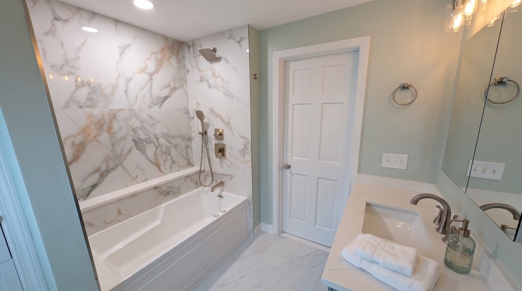 Remodeled bathroom with marble tub surround in Massachusetts