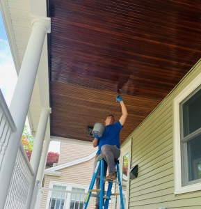 Painter working on an exterior porch ceiling in Massachusetts